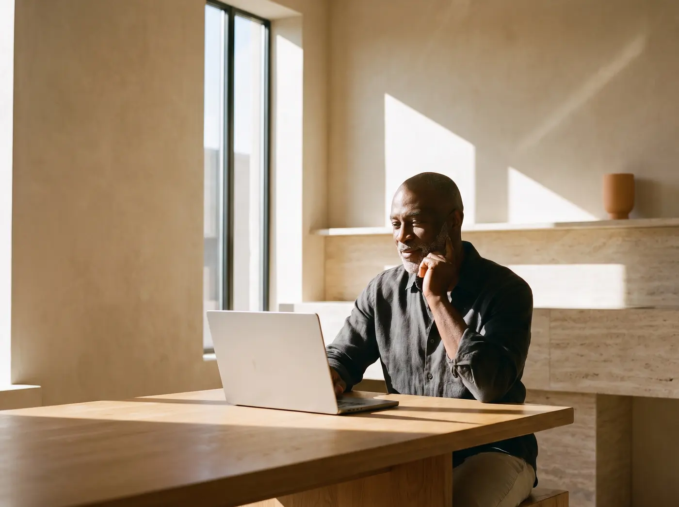 A man at his kitchen table on a relaxed video consultation with a clinician